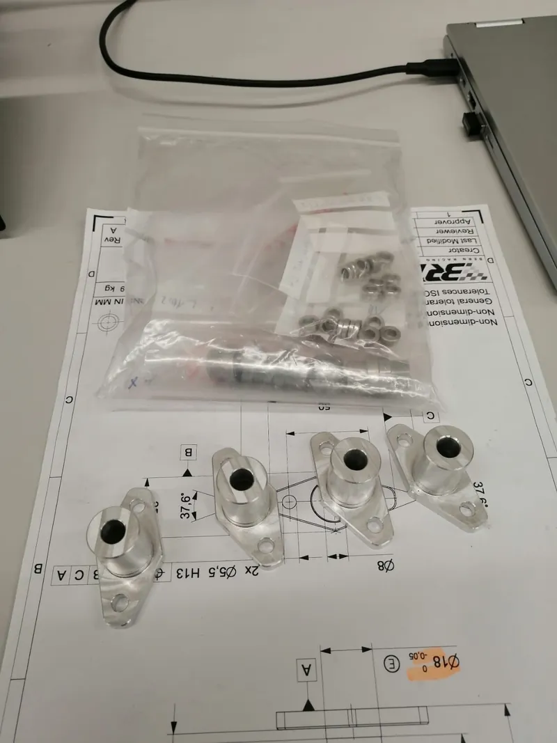 Machined parts next to their technical drawing